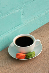 Cup of black coffee with green and red macaroons