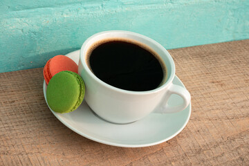Cup of black coffee with two macaroons