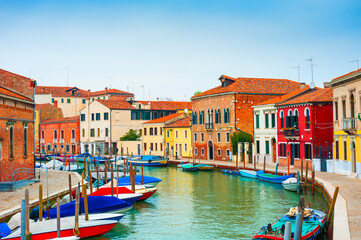 Fototapeta na wymiar Colorful houses on the canal in Murano island, Venice, Italy. Famous travel destination.