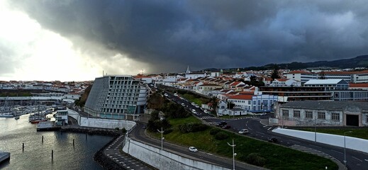Rainy day with a rainbow in a small town with orange roofs in the Azores