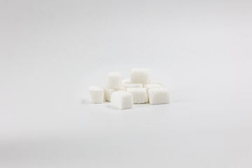 Fototapeta na wymiar Many sugar cubes in a pile on a white background