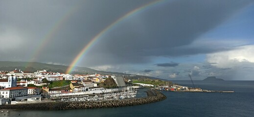 Naklejka na ściany i meble Rainy day with a rainbow in a small town with orange roofs in the Azores