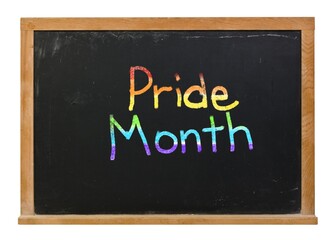 Pride month written in colorful chalk rainbow colors on a black chalkboard isolated on white