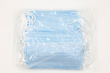 pack of disposable blue new medical masks isolated on white background top view