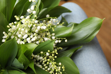 Woman with lily of the valley flowers, closeup