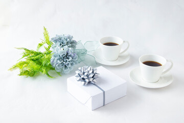 Obraz na płótnie Canvas 美しいブルーグレーのダリアの花束と銀色のリボンのプレゼントとコーヒー（白バック）