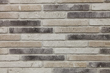 Textured gray brick wall, stone texture. Decorative styles for wall decoration. Background, gray, decorative brick. A structural surface imitating an old brick. Loft-style decor. A structural surface 