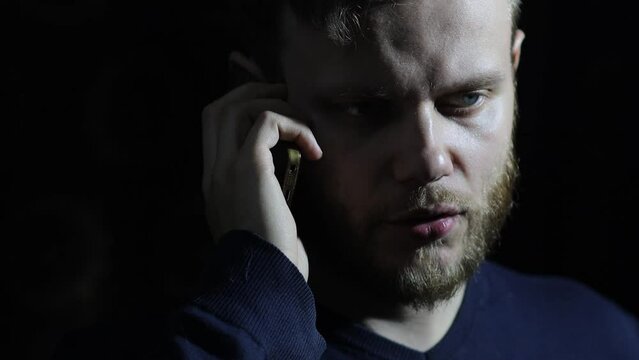 man is talking on the phone in the dark, the concept of blackmail and loan debts.