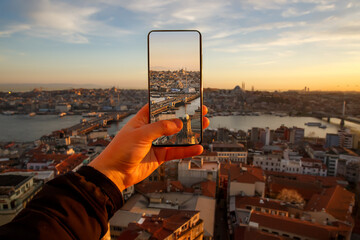 Naklejka premium Istanbul at sunset, Turkey. Taking a photo cityscape by cell phone.