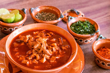 Menudo sobre plato de barro con acompañamientos 