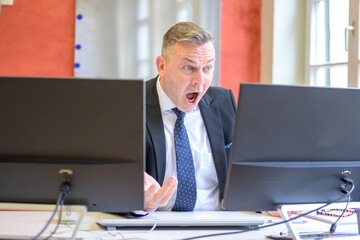 Businessman staring at a computer with stupefication