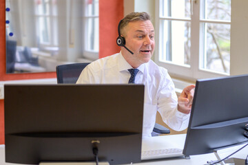 Businessman wearing headset on a conference call