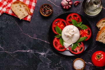 Caprese salad with tomatoes, burrata cheese and basil.