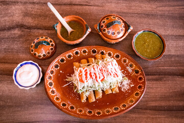 Tacos dorados con ingredientes alrededor 