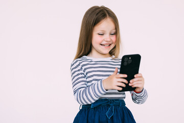 little girl looks at the phone isolated on white background