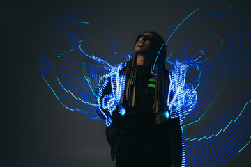 African american woman in smart glasses posing near abstraction on grey background.