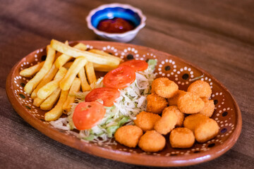 Palomitas de pollo con ensalada y papas a la francesa 