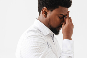 Black tired man with headache rubbing his forehead