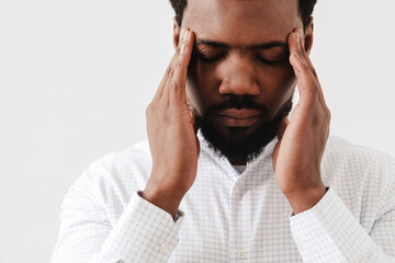 Black tired man with headache rubbing his temples