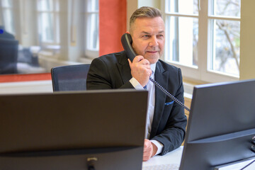 Businessman on a phone call at his desk in office