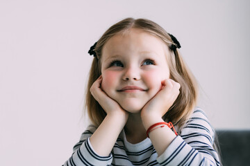 Portrait of cute thoughtful child girl. Dreaming people.