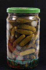 Bocal de cornichons en gros plan sur fond noir