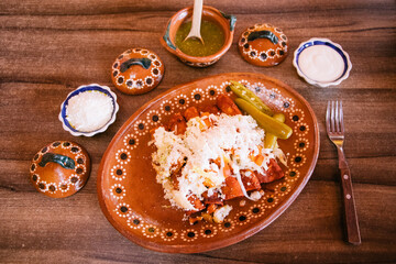 Enchiladas rojas con crema, queso y salsa verde 