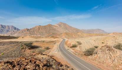 A road going thru the deserted mountains of the Sultanate of Oman. 