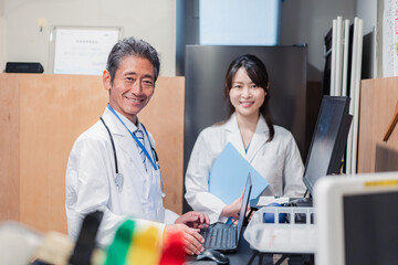 Obraz premium ナースステーションで打ち合わせをする医療従事者たち