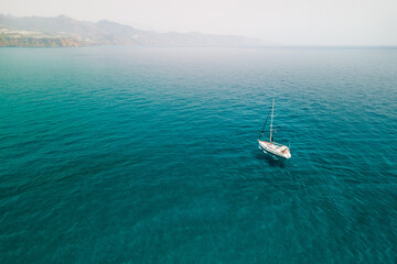 A lonely yacht sailing in turquoise waters of the Mediterranean sea, a vacation yacht