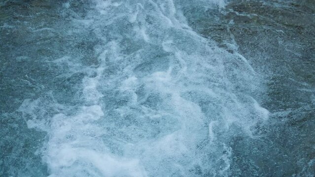 Close up of water surface splashes from a wild mountain river. Slow motion, 