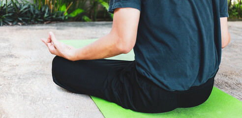 Young Asian man practicing yoga, breathing, meditation, adha exercise, padmasana, half lotus pose...