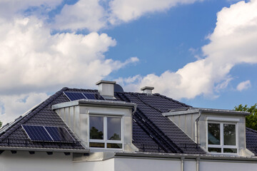 Modern Roof with Solar Panels, Dormer Windows. Tiled Roof with Chimneys, Snow guards, ladders and electrically heated gutters. Solar panels on roof of house. 
