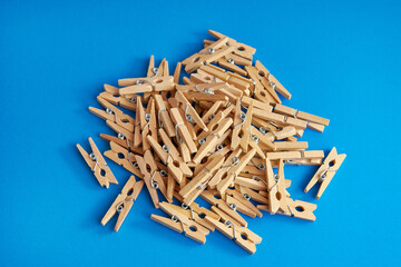 Little wooden clothespins on a blue background.