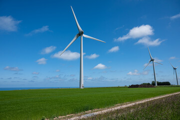 Fototapeta premium View on modern wind mills, green grain fields and blue Atlantic ocean in agricultural region Pays de Caux in Normandy, France