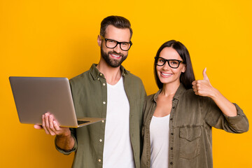 Photo of cool young brunette people hold laptop thumb up wear eyewear shirt isolated on yellow...