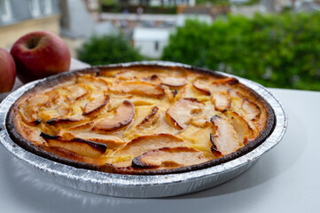Tasty sweet French dessert, baked apple cake and view on old houses of Etretat, Normandy, France
