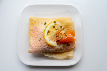 Cuisine of Normandy, galette pancake filled with goat cheese and smoked salmon served with fresh lemon