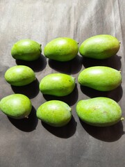 Raw mango in black background. Mango is a popular fruit, it is also called the king of fruits.  Its pickle is very tasty. It is cooked and made into vegetables. Green Mango in black background. 