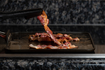 Bacon frying on the stove top with a shallow depth of field and copy space