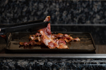 Bacon frying on the stove top with a shallow depth of field and copy space
