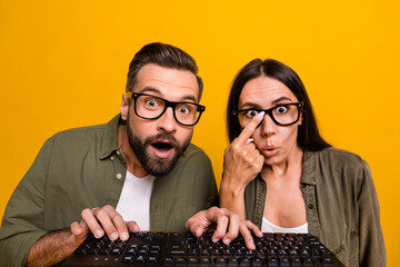 Photo of funky millennial brunet couple type keyboard wear eyewear shirts isolated on yellow background - obrazy, fototapety, plakaty