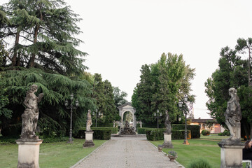 beautiful alley in the park with statues in italy