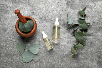 Obraz na płótnie Canvas Flat lay composition with bottles of eucalyptus essential oil on grey table