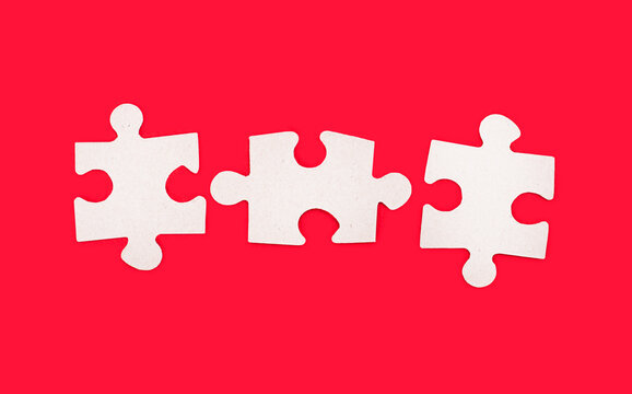 Three blank jigsaw puzzles with space for inserting text on a bright red background. Copy space