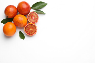 Ripe sicilian oranges and leaves on white background, flat lay. Space for text