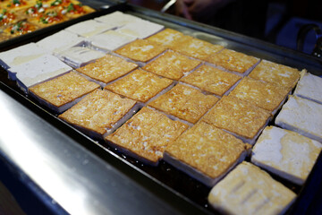 Traditional stinky tofu on hot pan, famous Beijing street food. 