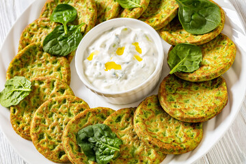 spinach pancakes on white plate with sauce