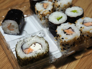 Japanese sushi food. Maki and rolls with tuna, salmon, shrimp, crab and avocado. Sushi rolls in container