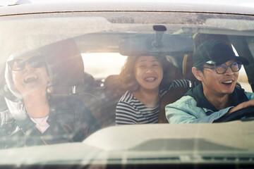group of asian tourists traveling by car and having a good time